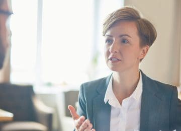 Image of business woman discussing a reaction plan to fraud with coworker