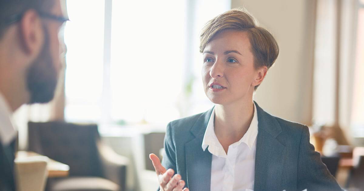 Image of business woman discussing a reaction plan to fraud with coworker