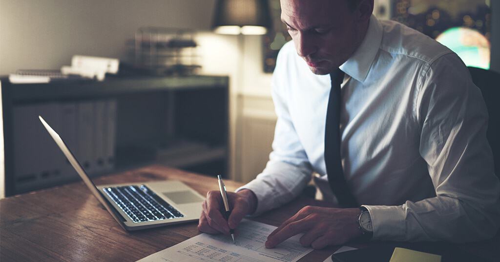 Image of accountant carefully reviewing document with new income tax withholding tables for 2018