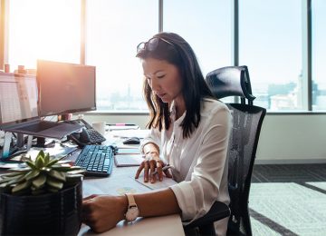 Image of business woman reviewing charts and reports in office