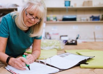 Image of older woman in home workshop reviewing her charitable contribution deductions