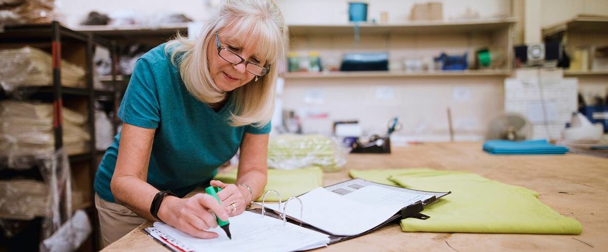 Image of older woman in home workshop reviewing her charitable contribution deductions