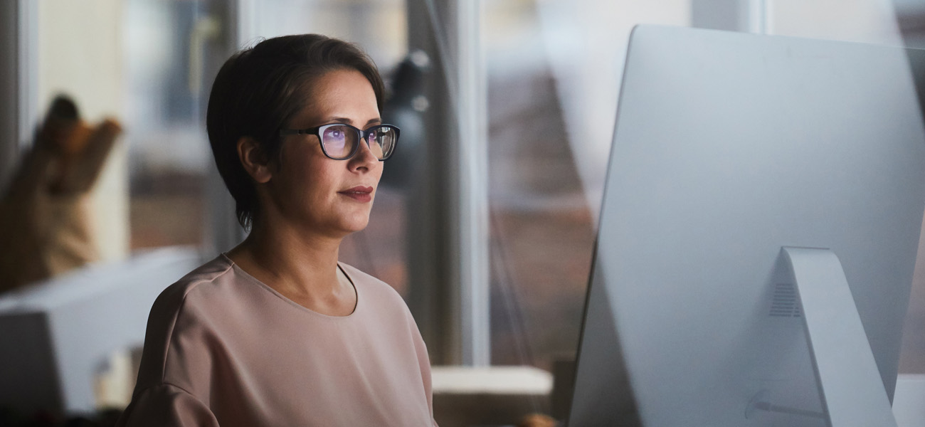 mature woman sits at computer and reads the new net operating loss rules under the cares act