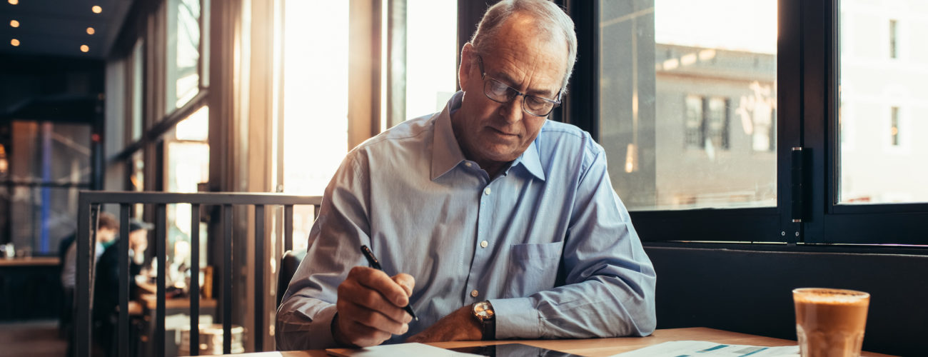 Mature man reviews important retirement planning ages in a cafe