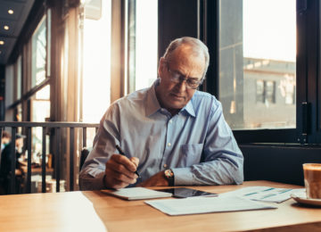 Mature man reviews important retirement planning ages in a cafe