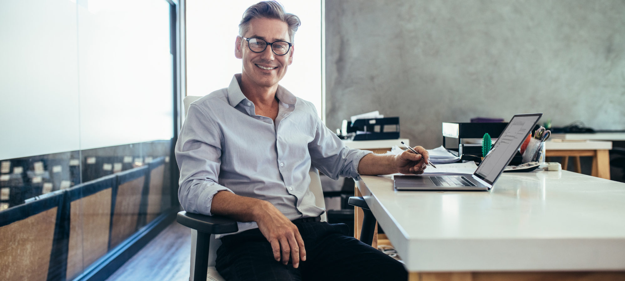 Mature businessman who qualifies for white-collar exemption sitting in office