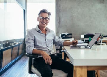 Mature businessman who qualifies for white-collar exemption sitting in office