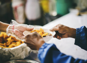 Volunteers feeding meals to homeless - Mel Trotter gets accounting support from Beene Garter