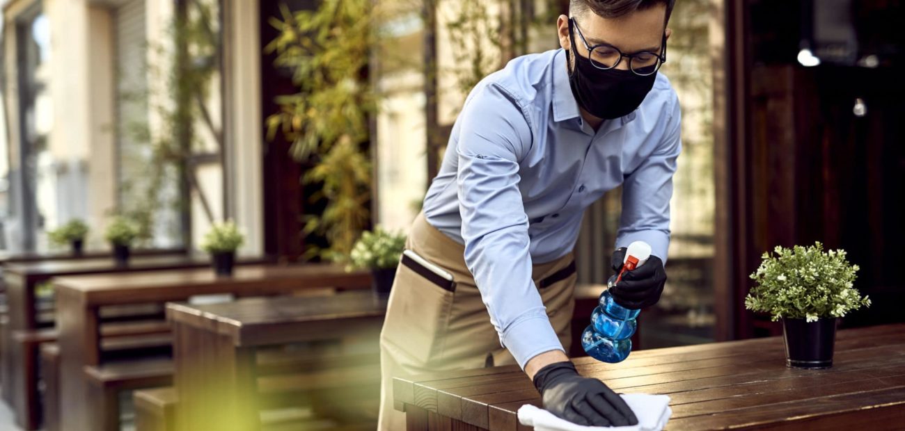 Young waiter cleaning tables after passing of American Rescue Plan Act of 2021