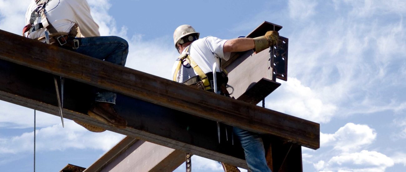 Image of two ironworkers putting up the skeleton of a building - contractors in Michigan