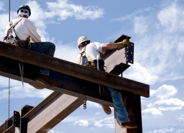 Image of two ironworkers putting up the skeleton of a building - contractors in Michigan