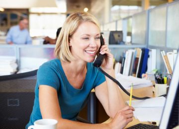 Image of woman talking on phone in office and paying state and local tax