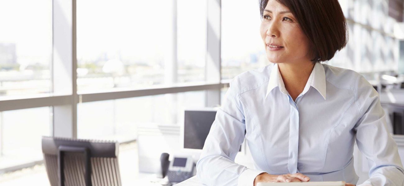 Image of business woman sitting in office and thinking about finding buyer for her business