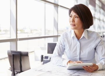 Image of business woman sitting in office and thinking about finding buyer for her business