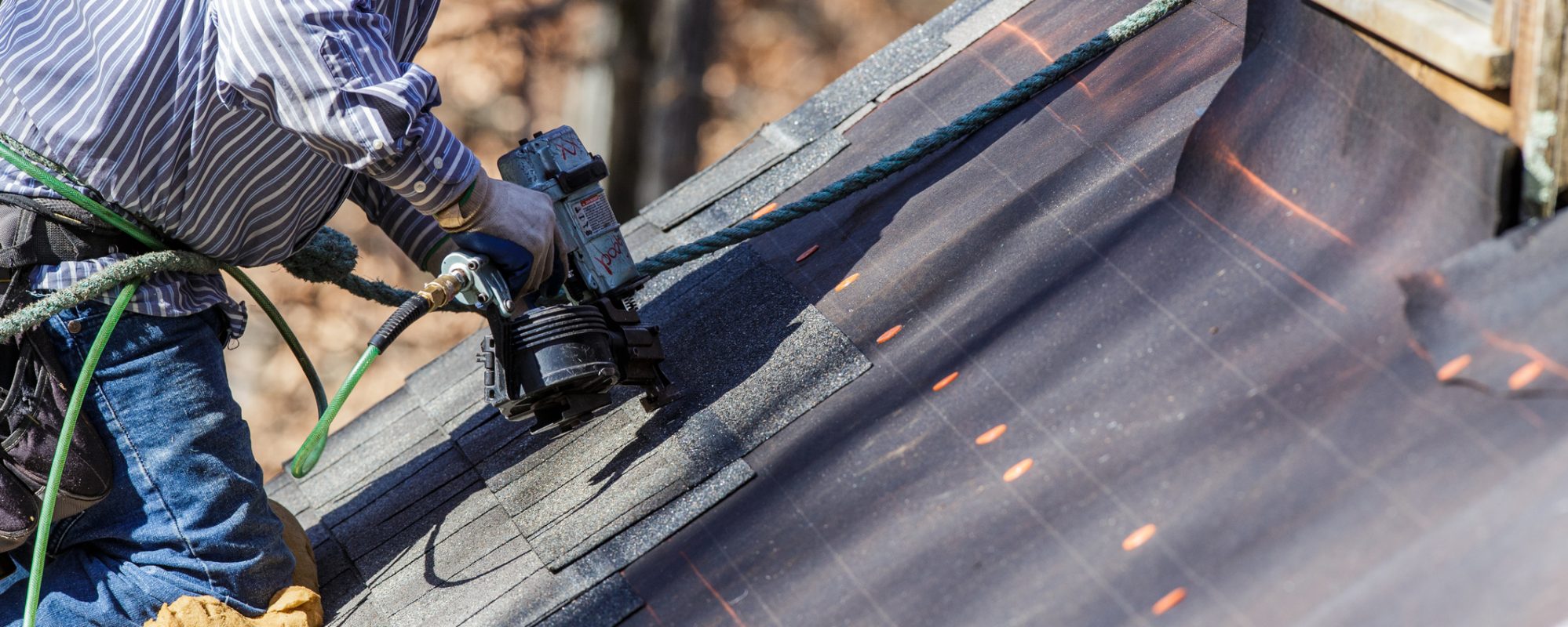 Image of roofer nailing shingles and repairing roof - casualty gain