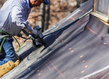 Image of roofer nailing shingles and repairing roof - casualty gain