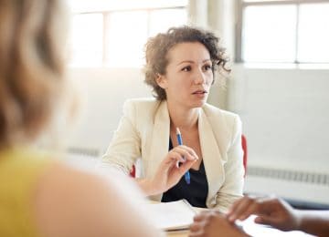 Female speaking to business team and discussing Michigan's paid medical leave act