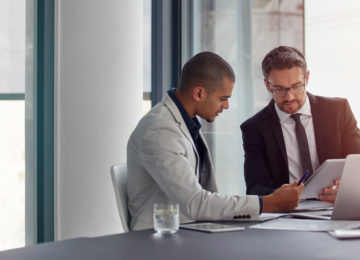 two business men discuss the payroll tax deferral in a meeting