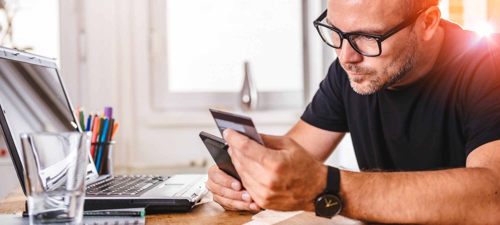 Image of man paying for online purchase with credit card on smart phone