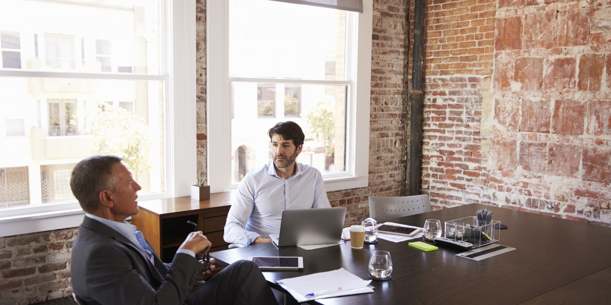 Image of two businessmen having a financial meeting about accounting methods changes in conference room