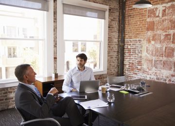 Image of two businessmen having a financial meeting about accounting methods changes in conference room