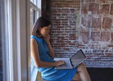 Business woman on laptop reviewing her nonprofit financial problems