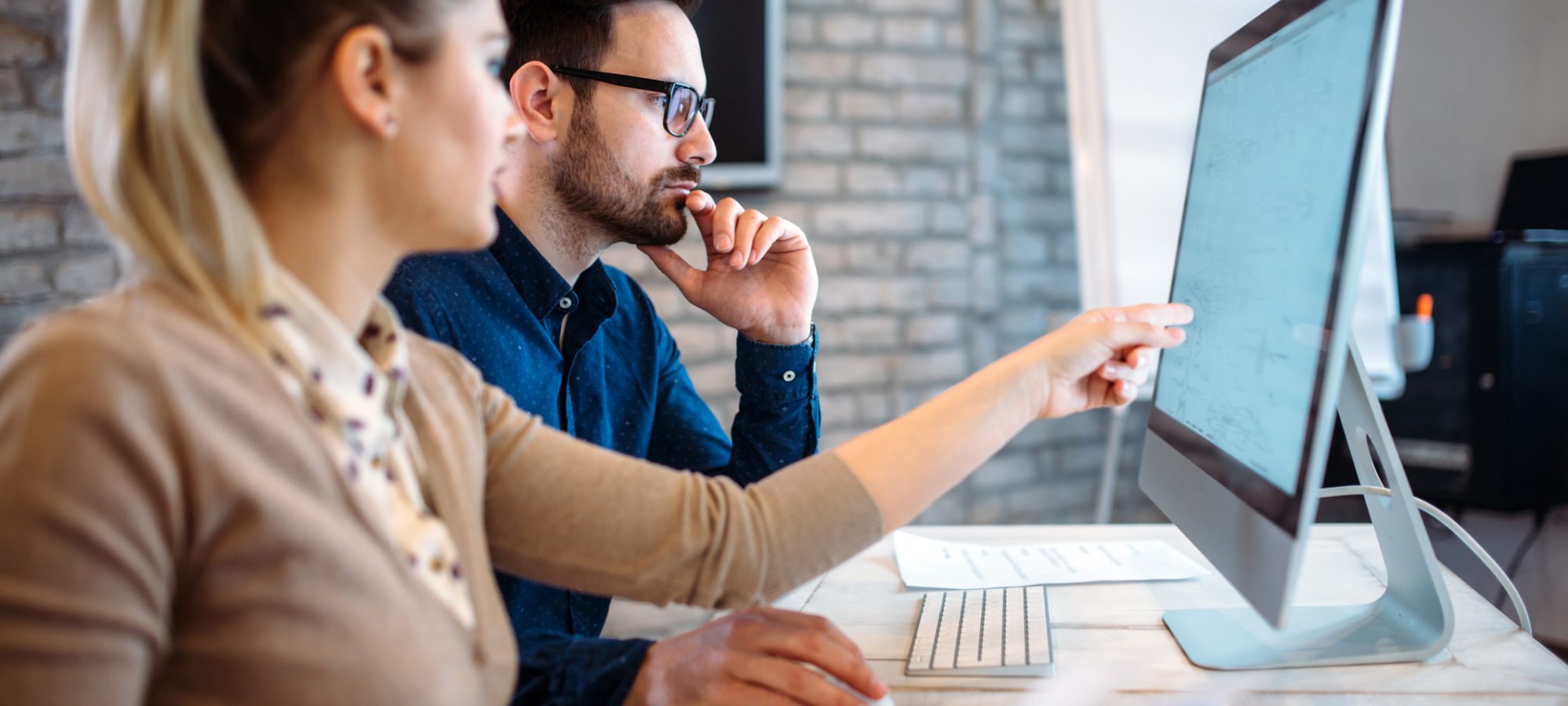 Image of financial professionals reviewing accounting software and benefits of accounting outsourcing