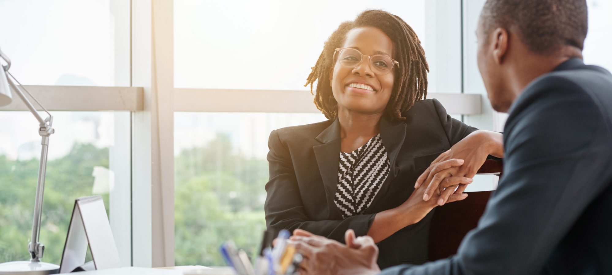 Image of two business professionals having a conversation in office setting