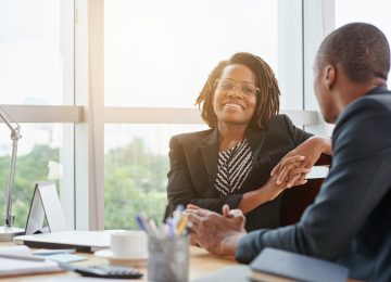 Image of two business professionals having a conversation in office setting