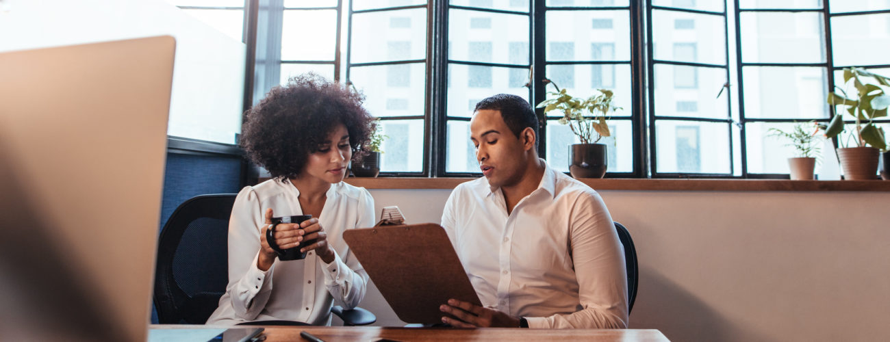 Two professionals discussing an employee benefit plan audit while sitting at a desk