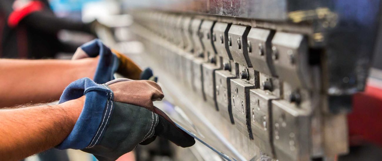 Image of man bending sheet metal in factory - tangible personal property or real property