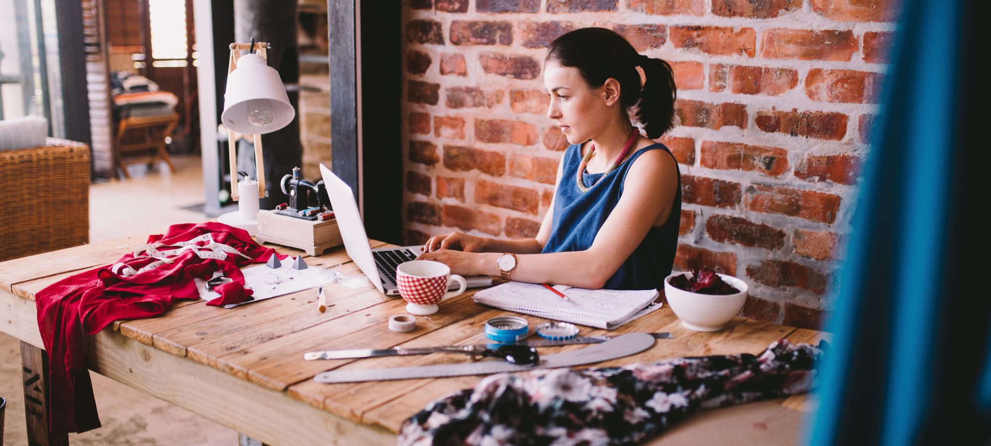 Image of young businesswoman working on laptop and documenting the fair market value of items