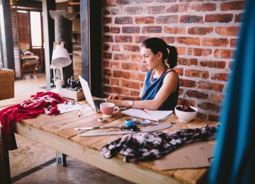 Image of young businesswoman working on laptop and documenting the fair market value of items