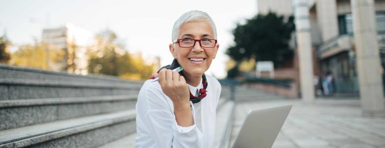 Image of older business woman sitting outside and planning for future