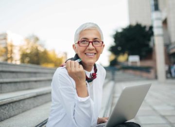 Image of older business woman sitting outside and planning for future