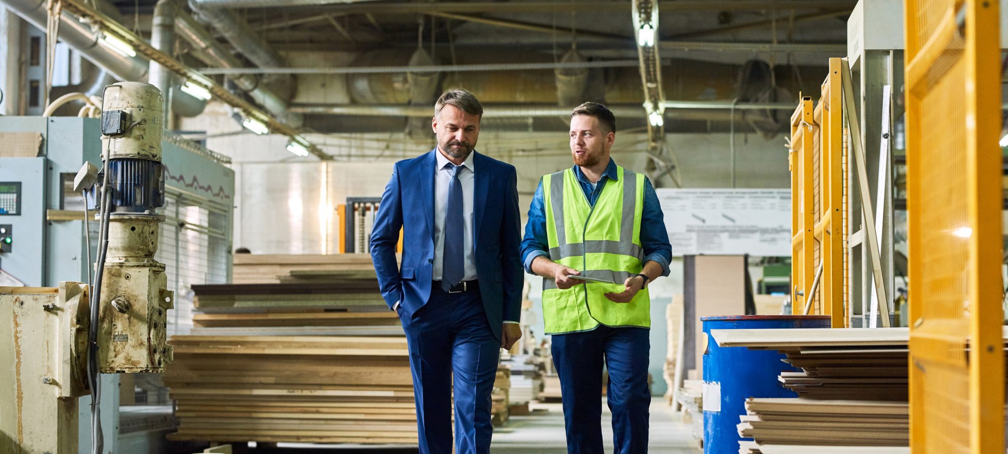 Image of young business owner giving tour of factory to ESOP valuation expert