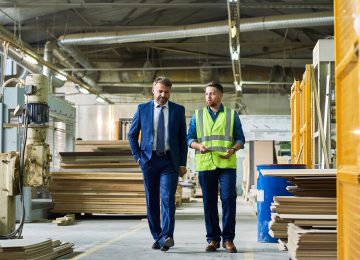 Image of young business owner giving tour of factory to ESOP valuation expert