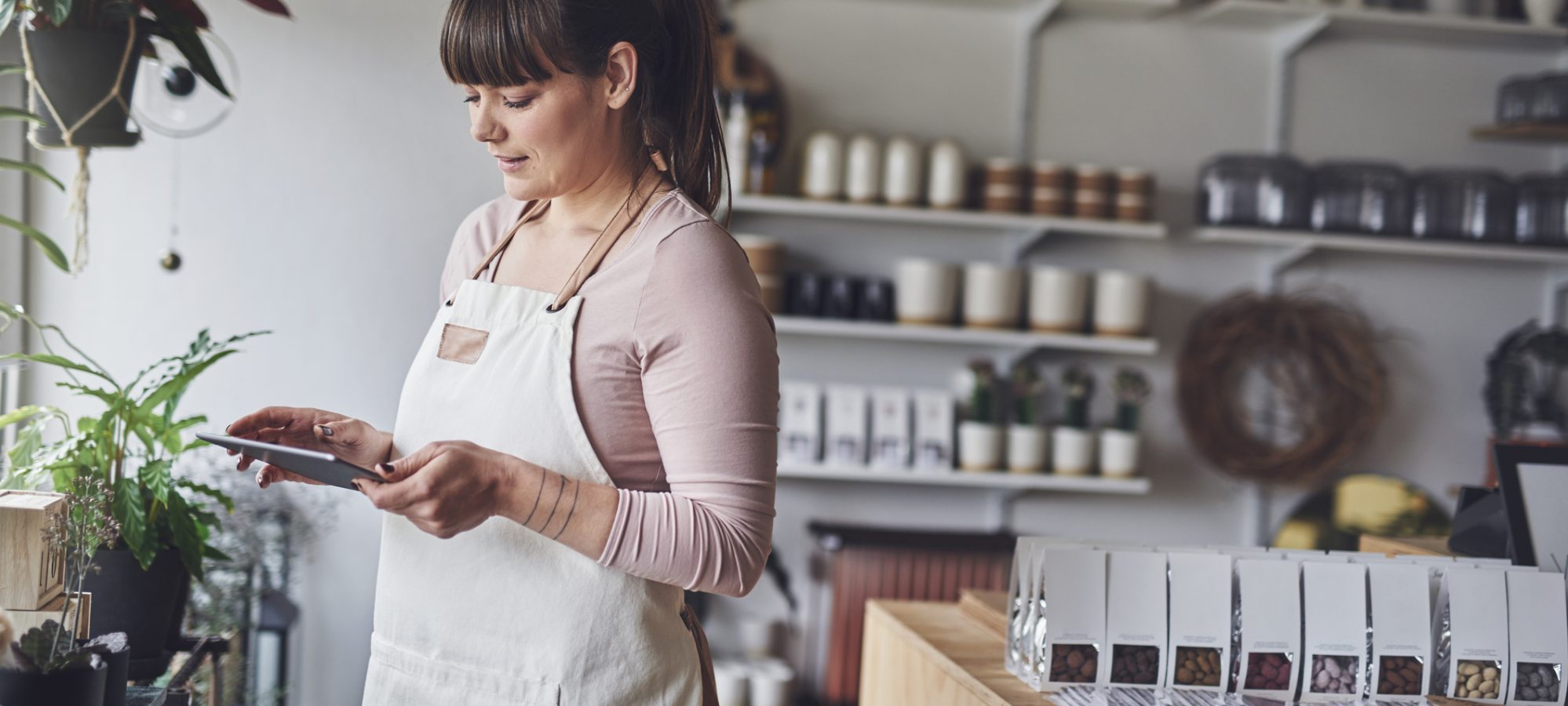 Image of floral shop owner calculating her alternative minimum tax exemption on tablet