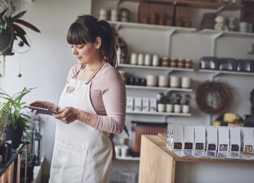 Image of floral shop owner calculating her alternative minimum tax exemption on tablet