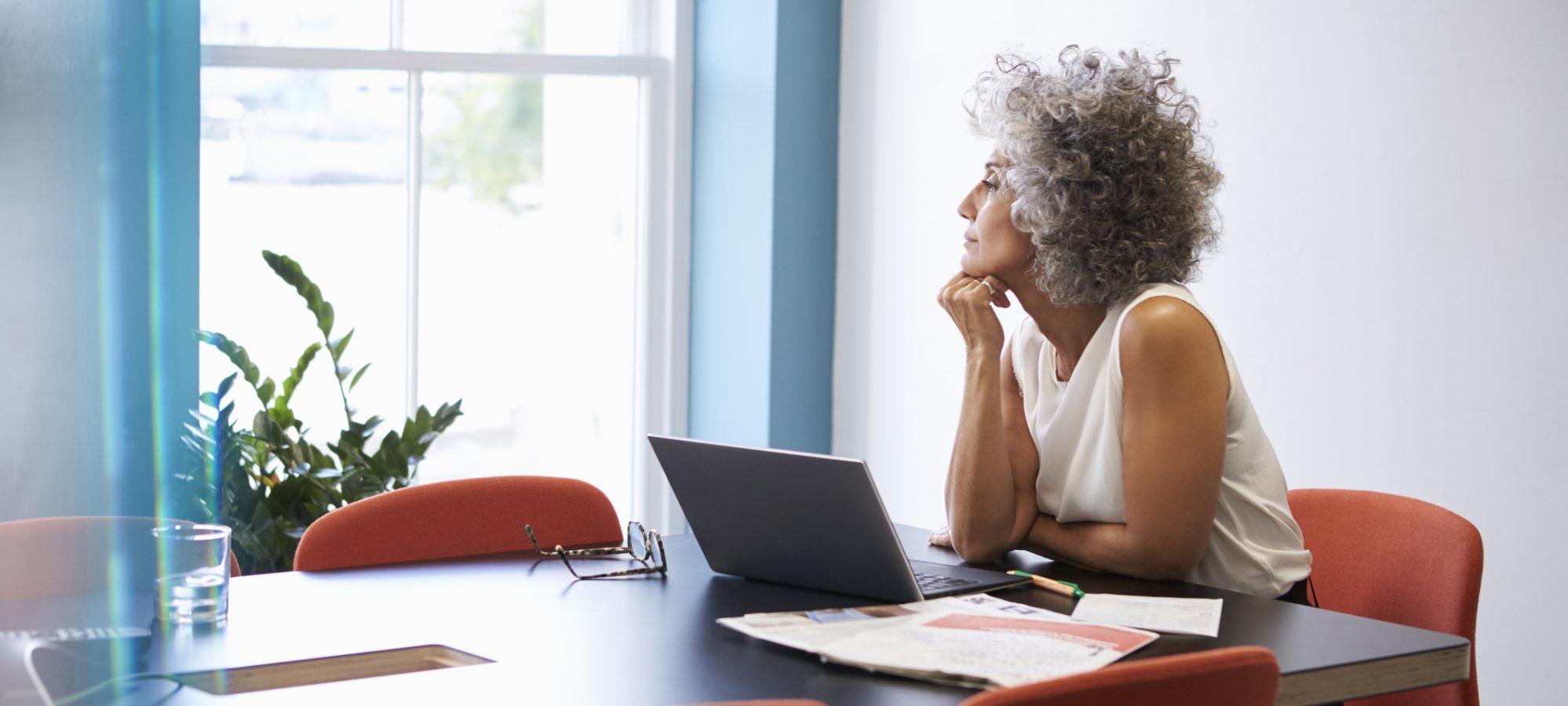 Image of woman looking of window in boardroom and reviewing NOL rules