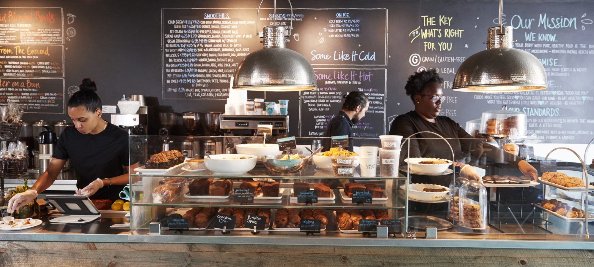 Image of minimum wage staff working behind counter in coffee shop