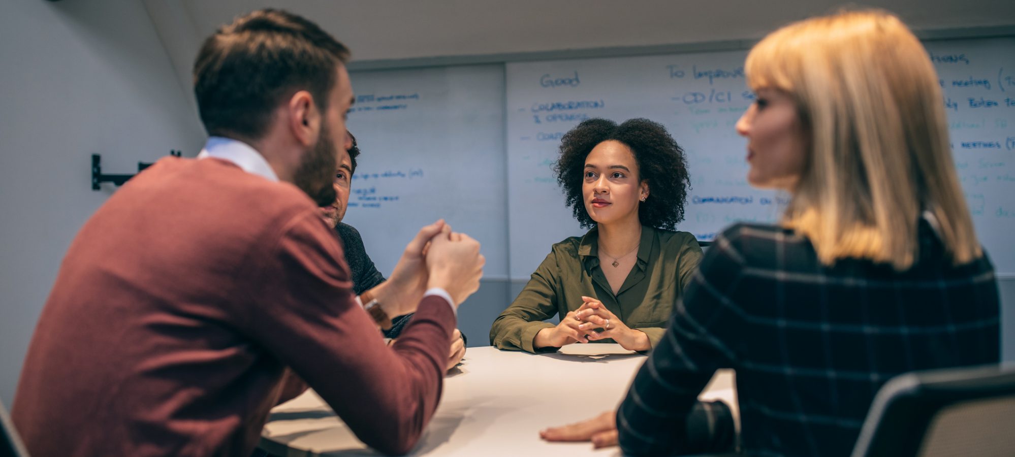 Image of people sitting around table and discussing sale agreement of business