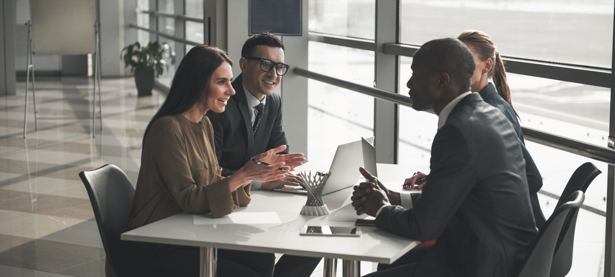 Group of professionals sitting at office table and talking about their business appraisal