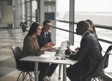 Group of professionals sitting at office table and talking about their business appraisal