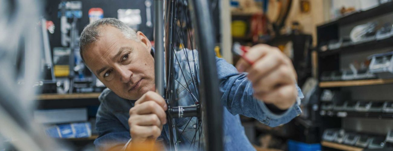 Image of business owner repairing bike in shop - eligible for QBI deduction