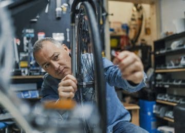 Image of business owner repairing bike in shop - eligible for QBI deduction