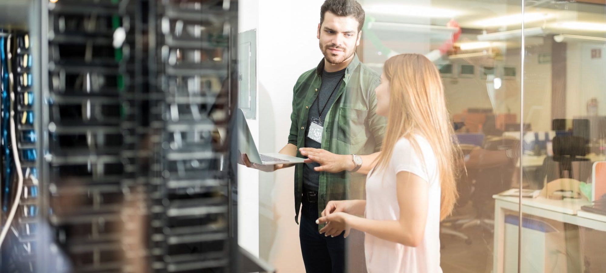 Two business people standing in server room evaluating cloud vs. on-premise solutions